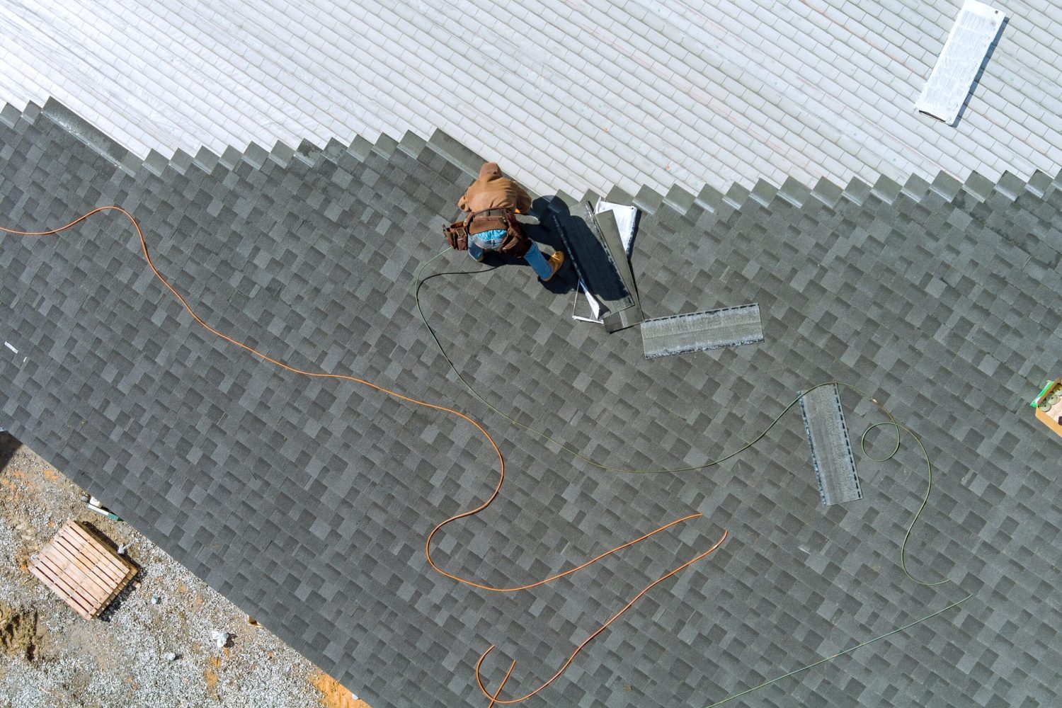 Asphalt shingles being installed and nailed on a roof