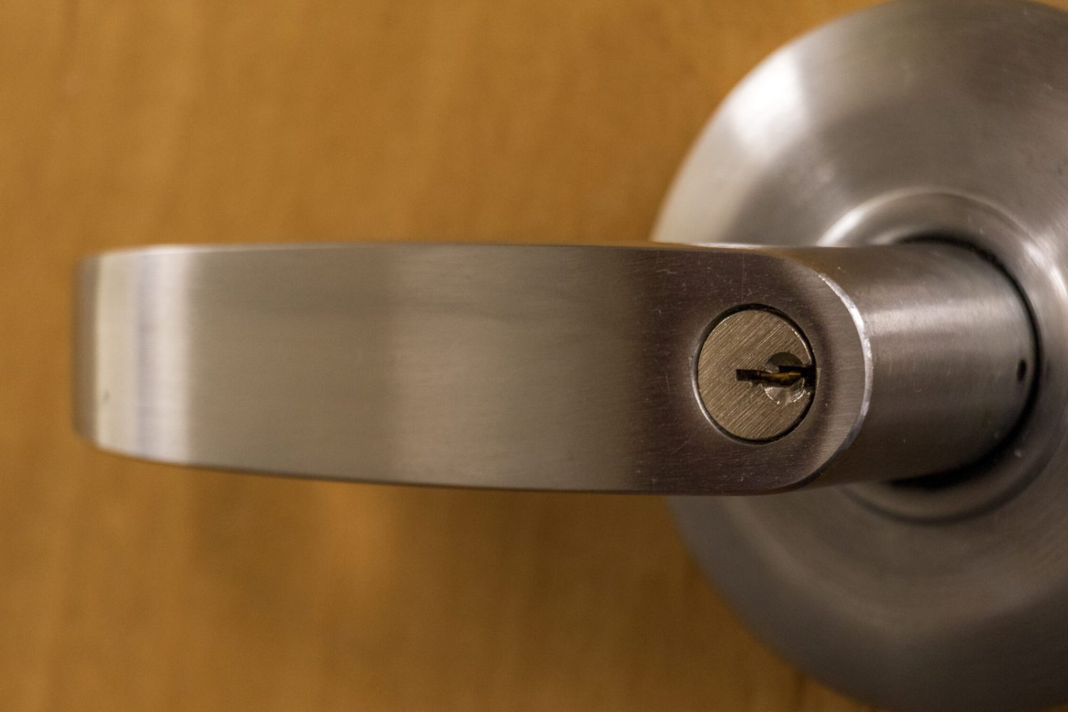 A close view of a wooden door with a brushed metal handle